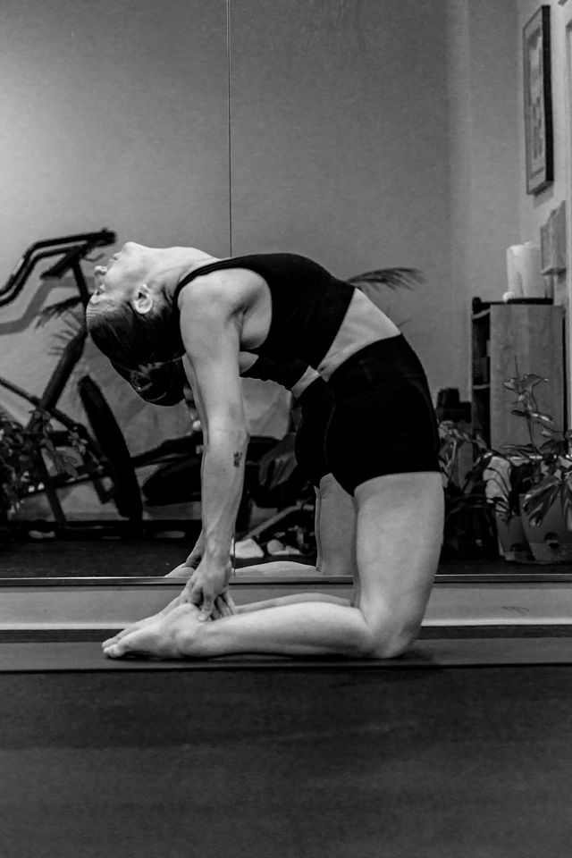 Yoga practitioner kneeling in a gentle backbend on the mat